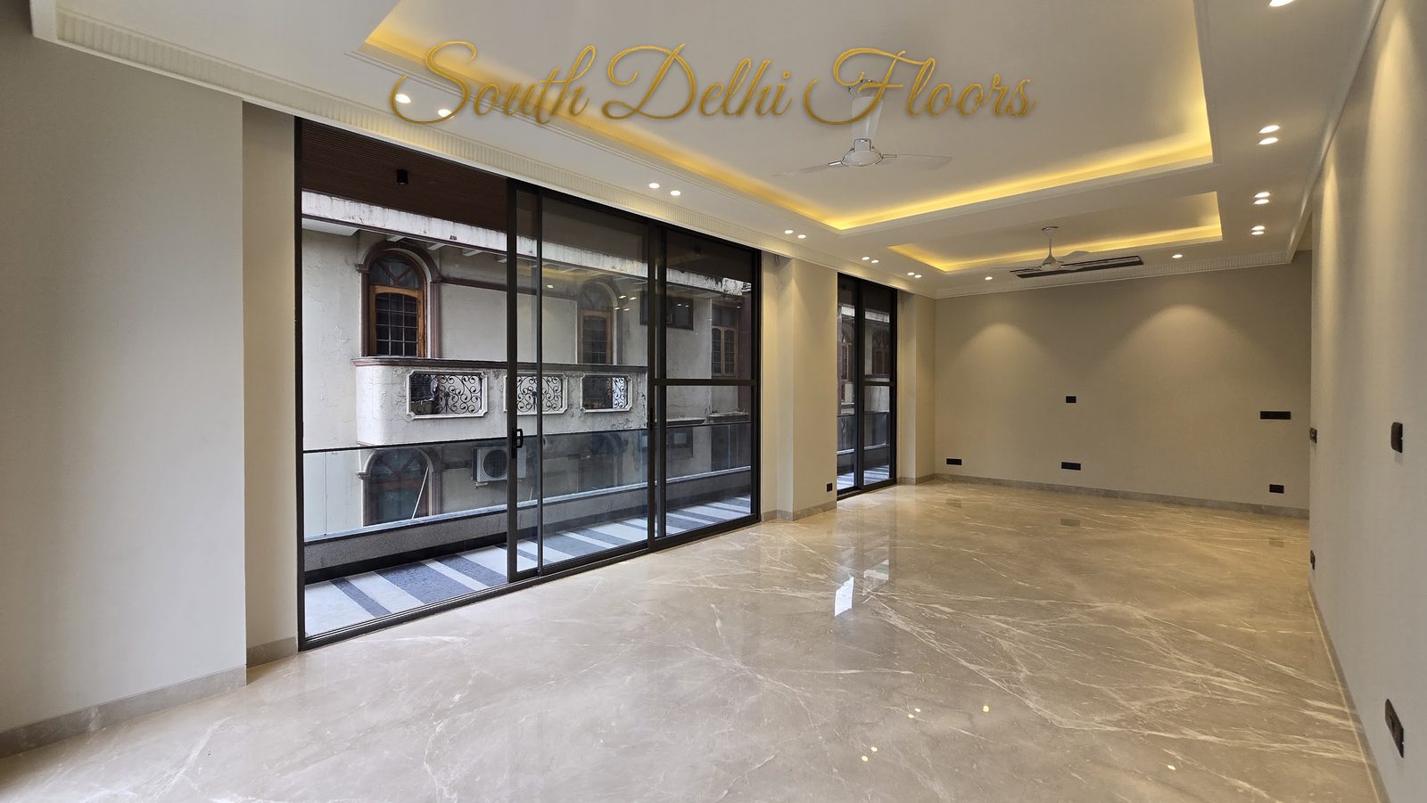 Wide view of the living hall with glass sliding wall and cove ceiling at an RPB Homes JCR Homes luxury property in South Delhi by Mahavir Bihani and Rajat Bihani