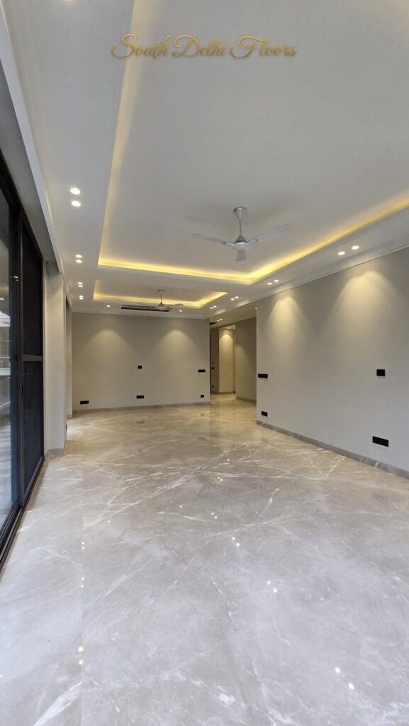 Living room with a linear cove ceiling, glass wall and cream marble floor at an RPB Homes JCR Homes luxury builder floor in South Delhi by Mahavir Bihani and Rajat Bihani