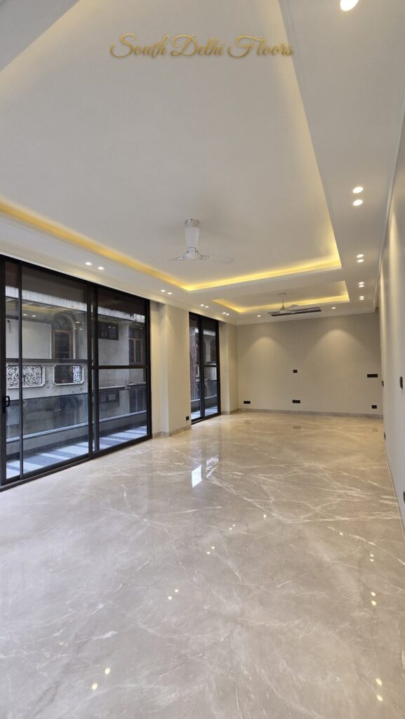 Side view of the living room with long glass wall and cove-lit ceiling at an RPB Homes JCR Homes luxury home in South Delhi by builders Mahavir Bihani and Rajat Bihani