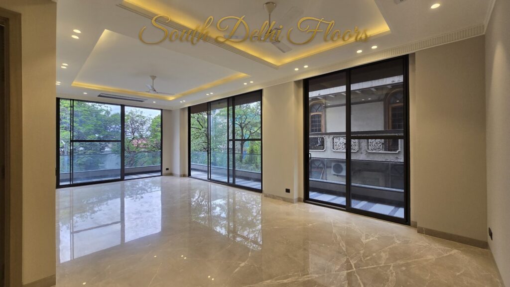Living room with wraparound glass walls and tree view at an RPB Homes JCR Homes luxury property in South Delhi by Mahavir Bihani and Rajat Bihani