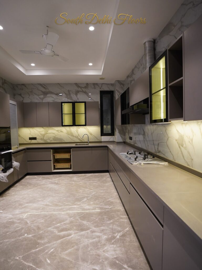 Wide view of the modular kitchen with Calacatta-style marble walls and grey cabinetry at an RPB Homes JCR Homes luxury builder floor in South Delhi by Mahavir Bihani and Rajat Bihani