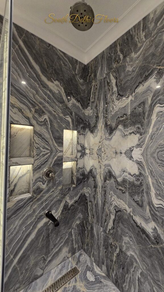 Shower area with book-matched grey marble, lit niches and rain shower at an RPB Homes JCR Homes luxury home in South Delhi by builders Mahavir Bihani and Rajat Bihani