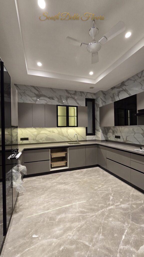 U-shaped modular kitchen with grey cabinets and marble walls at an RPB Homes JCR Homes luxury home in South Delhi by builders Mahavir Bihani and Rajat Bihani