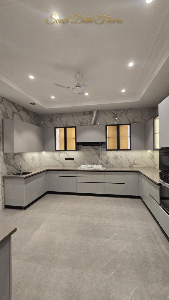 White modular kitchen with marble walls and backlit cabinets at an RPB Homes JCR Homes luxury residence in South Delhi by developers Mahavir Bihani and Rajat Bihani