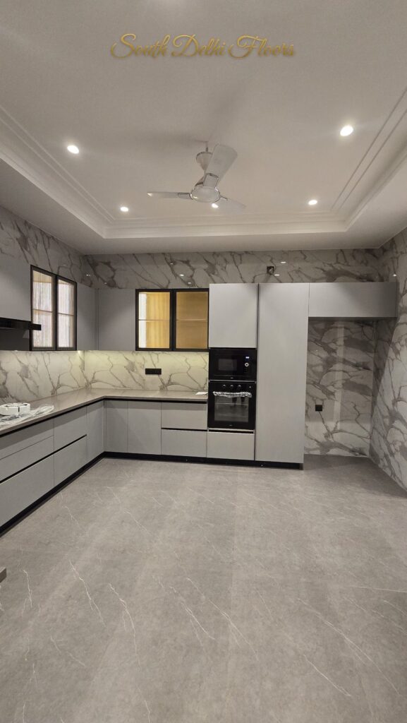 Wide view of the white modular kitchen with oven tower at an RPB Homes JCR Homes luxury home in South Delhi by builders Mahavir Bihani and Rajat Bihani