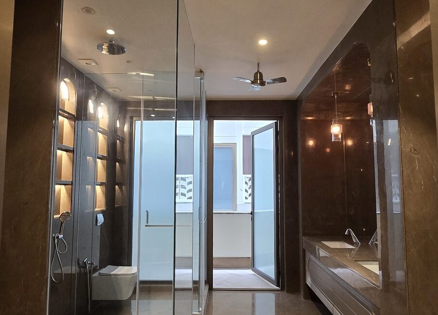 RS Buildtech Bathroom with Glass Shower and Balcony Door | Luxury Builder Floor by Ravinder Singh Marwah