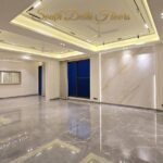 Living room of the triplex in Vasant Vihar, B Block, with Italian marble floors, a marble feature wall and cove lighting