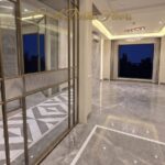 Living room seen through a bronze-framed glass partition in the Vasant Vihar D Block homes, with marble floors and a chandelier